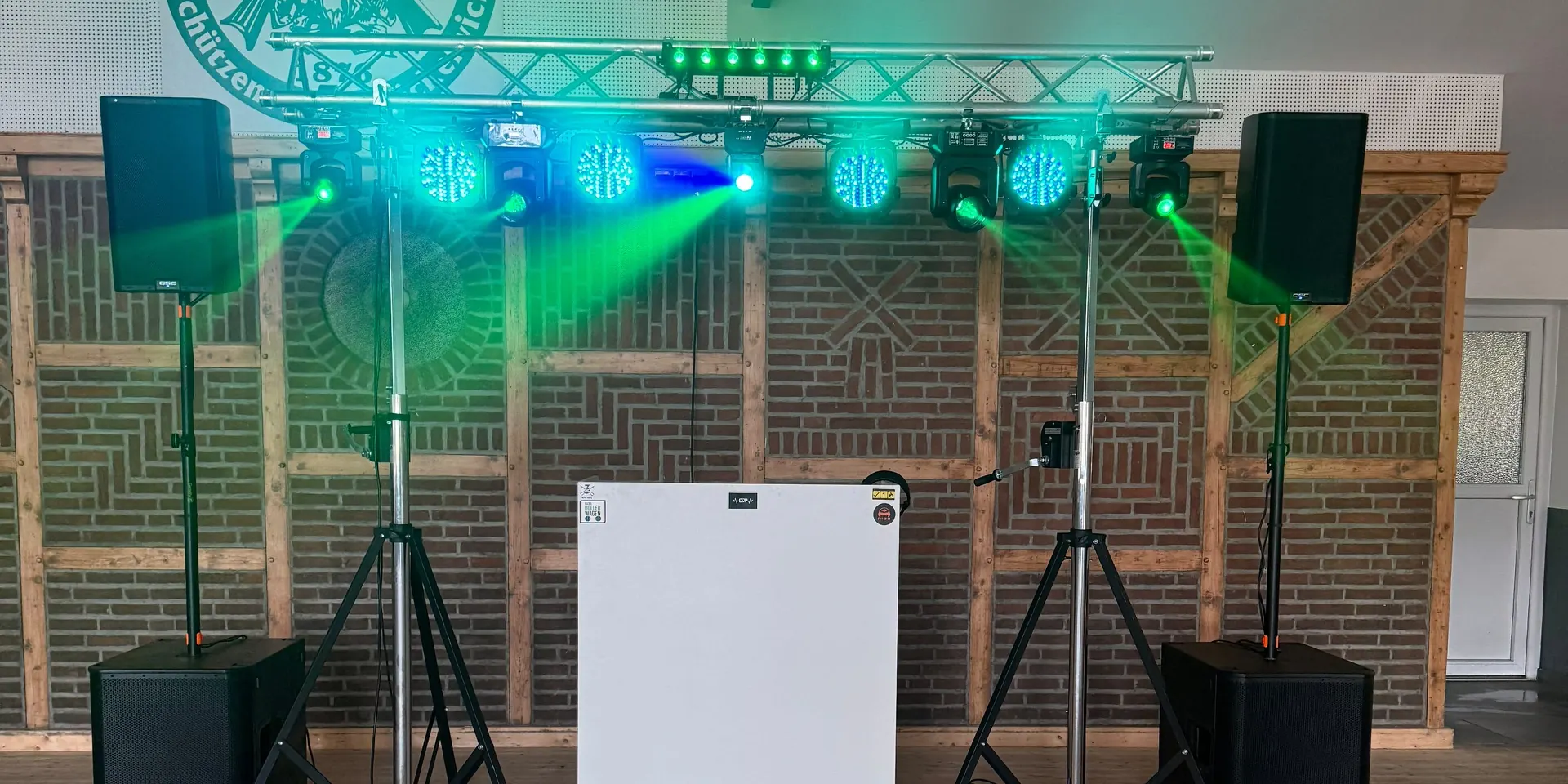 Mein Aufbau in einer Schützenhalle mit Traverse, Moving Heads, grünem Licht und vier Lautsprechern
