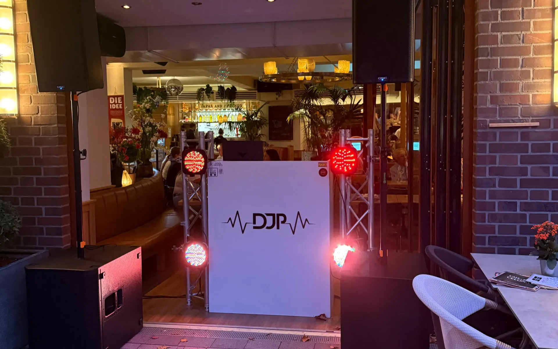 Mein DJ-Pult mit DJP-Logo im roten Licht vor dem Eingang des Cafe & Bar Celona
